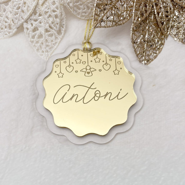 Gold decorative tag with 'Antoni' on a white background with gold and silver leaves.