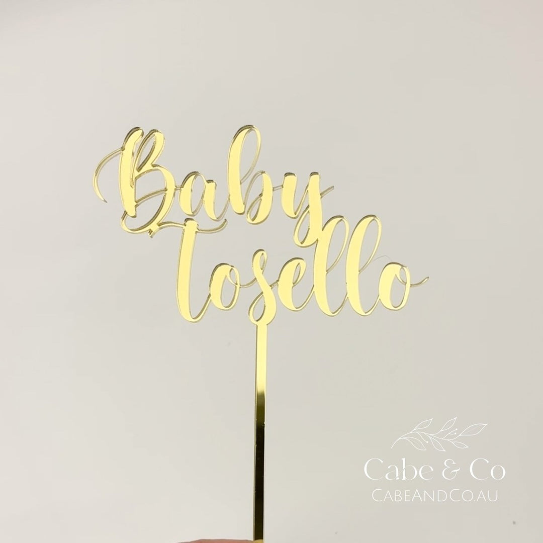 Gold metallic acrylic cake topper with the words &